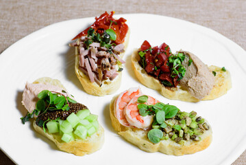 Bruschetta with sun-dried tomatoes and arugula, meat and seafood. Delicious breakfast or wine snack. close-up