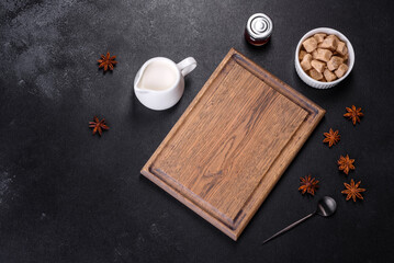Sugar, cinnamon and other spices on a wooden cutting board