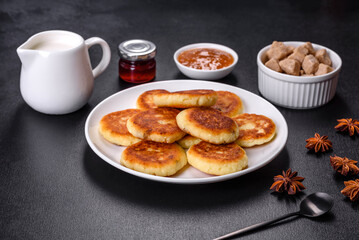 Cottage cheese pancakes with oats, syrniki on a black rustic background