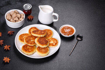 Cottage cheese pancakes with oats, syrniki on a black rustic background