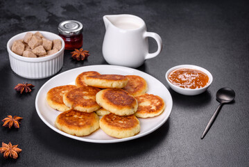 Cottage cheese pancakes with oats, syrniki on a black rustic background