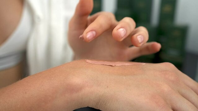 girl smearing foundation on her hand
