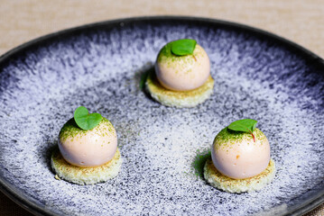 Three mini desserts with white vanilla cream inside on a blue plate