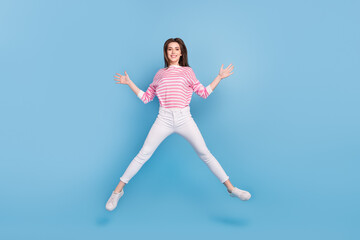 Full body portrait of satisfied cheerful person enjoy free time jumping isolated on blue color background