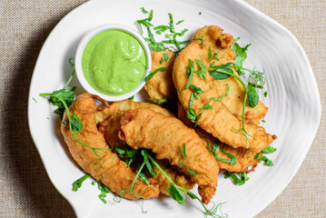 Fried southern shrimp with spicy sauce on a plate. top view