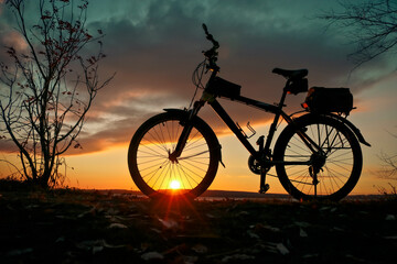 Bicycle silhouette on sunset background. Romantic sports background.