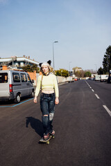 rebel aternative young woman outdoors riding skate skateboarding empty city streets
