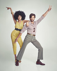 Lets dance. An attractive young couple standing together in retro 70s clothing.