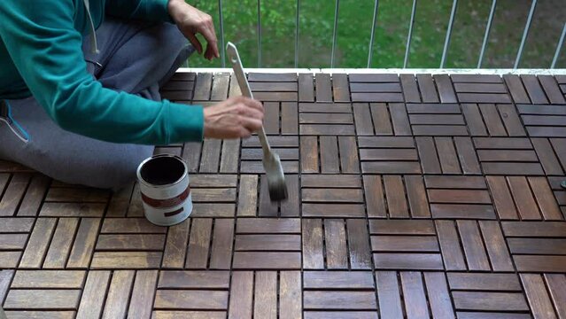 apply a protective varnish with a brush on the balcony wooden parquet as spring arrives - DIY projects bricolage  at home