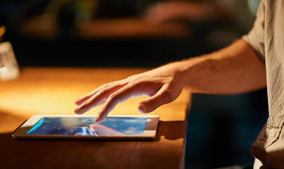 I have all I need at my fingertips. Cropped shot of a man using his digital tablet.