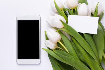 Smartphone mockup, bouquet of tulips with empty card. Greeting card mockup or template for flower business