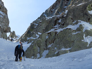 ski de rando et alpinisme dans un couloir de glace en montagne avec piolet et crampons et casque pour escalader en hiver dans la neige