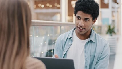 African businessman and unrecognizable caucasian businesswoman talking negotiating at office business meeting make partnership deal man consulting woman client with laptop job interview insurance