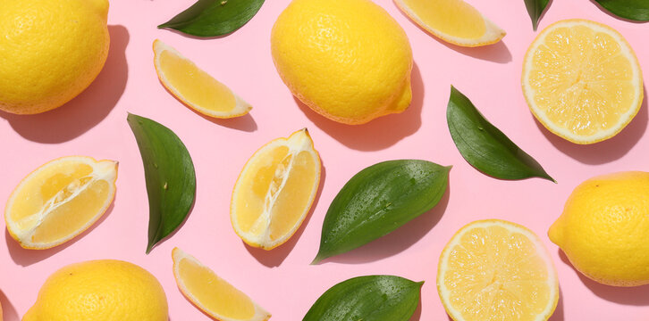 Many ripe lemons and leaves on pink background, top view. Texture for design