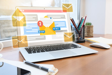 Laptop with symbols of new unread messages on screen at workplace