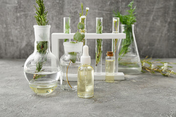 Laboratory glassware with natural essential oils on grunge background