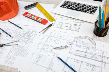 house project plan with work tools and helmet on desk