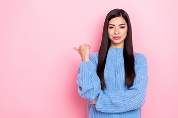 Portrait of attractive confident brown-haired girl demonstrating ad copy space isolated over pink pastel color background