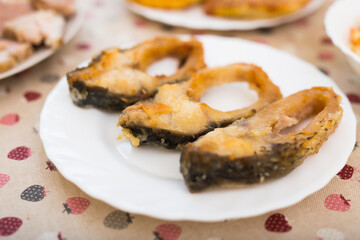 pieces of the middle part of the carp baked on a white plate