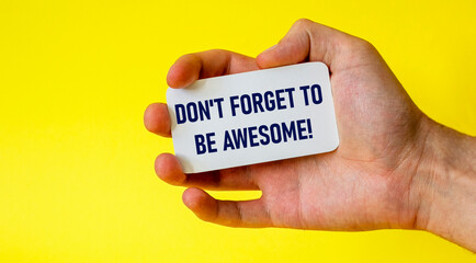 Don't forget to be cool business card in a male hand on a yellow background. Motivation for action