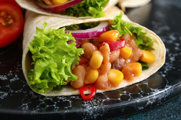 Board of tasty burrito with meat on black background, closeup