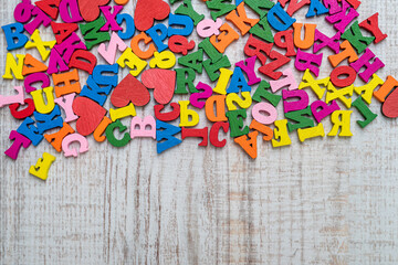 pile of multi-colored small wooden letters for primary education
