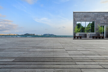 Empty wooden square and sea with city skyline in Hainan, China.