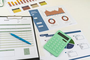 Fototapeta premium Financial paper charts with calculatop and pen on office desk