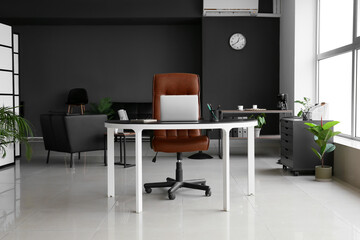 Comfortable workplace with laptop in modern office interior