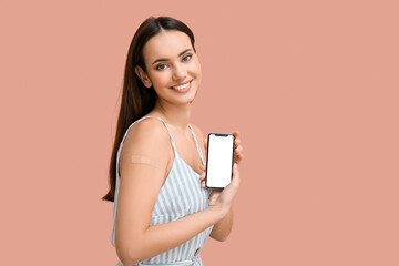 Young woman with applied medical patch and mobile phone on pink background