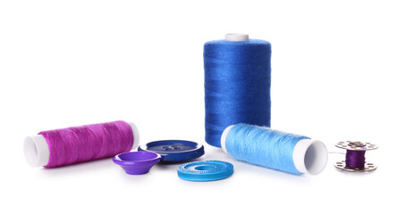 Multicolored thread spools and buttons on white background