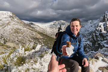 Lady giving chocolate while sitting in mountains