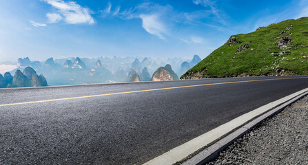 Asphalt highway and mountain natural landscape under blue sky in summer. Road and mountain...