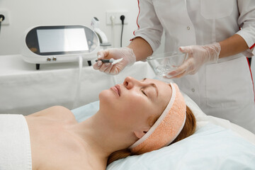 A woman receives laser treatment of the face in a cosmetology clinic, a concept of skin rejuvenation is being developed. laser peeling