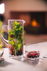 Refreshing can with water and a glass of water with fruit added. Interior with a fireplace. High quality photo
