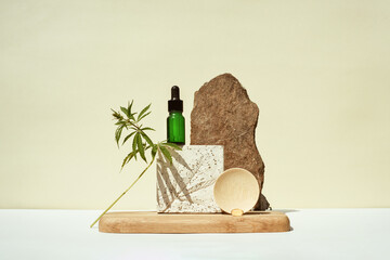 CBD oil in bottle and a cannabis bush, hemp in still life on geometric podium