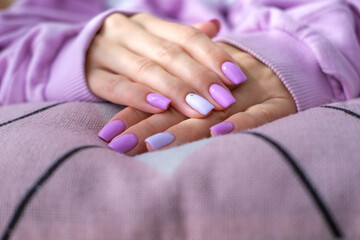 Women's hands with a fashionable very peri manicure . Hands with spring - summer purple square-shaped nails.