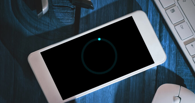Image of loading circle on smartphone in office - Powered by Adobe