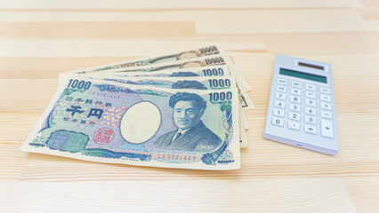 Japanese banknotes, coins and calculators placed on the table_b_10