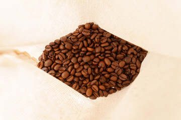 A view inside the bag on fragrant and aromatic roasted coffee beans. Selective focus