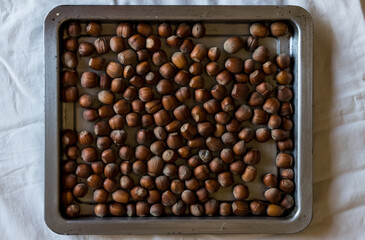 Photo of hazelnuts on a tray on table. Hazelnut nut health organic brown. Top view