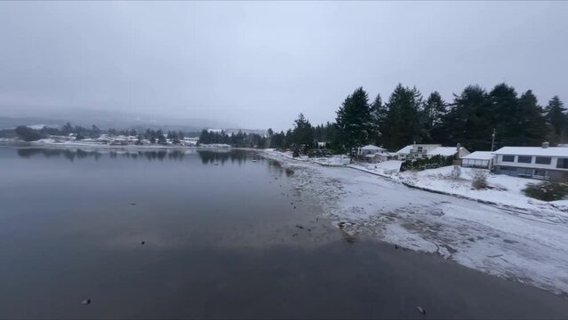 Snowy Shoreline Of Beach And Marina Of Sechelt Inlet During Winter In Canada. - aerial FPV