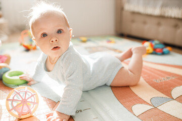 Portrait of wonderful baby girl laying on comfortable bed at home, adorable cute toddler look around with big interest, smiling, childhood and childcare concept - Powered by Adobe