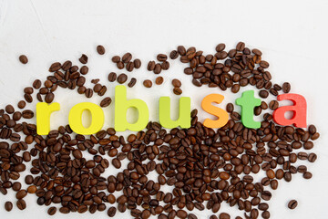 Black coffee beans seed scattered on table, dark coffee robusta. Selective focus