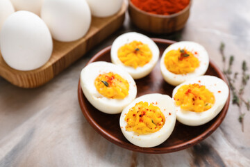 Plate, holder with eggs and paprika on grunge background, closeup. Easter celebration