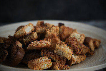Wooden plate with fried breadcrumbs dark background. Rustic setting and food.