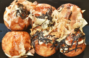 Takoyaki Japanese fried dumpling stuffed octopus dressing mayonnaise topping dry fish dipping with sweet soy sauce on plate