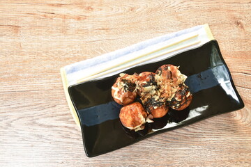 Takoyaki Japanese fried dumpling stuffed octopus dressing mayonnaise topping dry fish dipping with sweet soy sauce on plate
