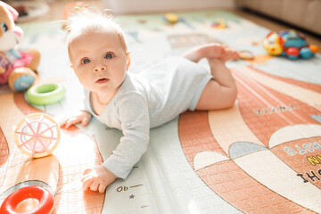 Portrait of wonderful baby girl laying on comfortable bed at home, adorable cute toddler look...