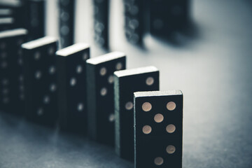 Black dominoes chain on table background